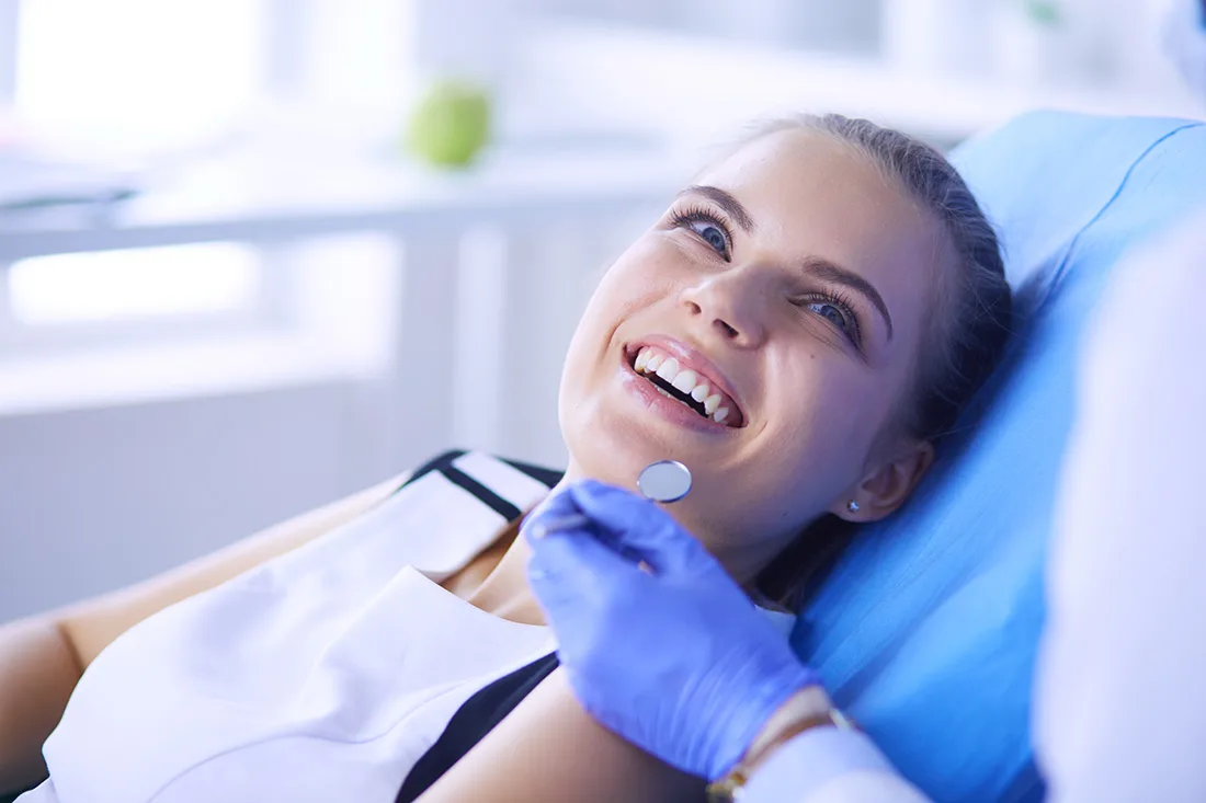 Smiling patient in a dental chair during an exam