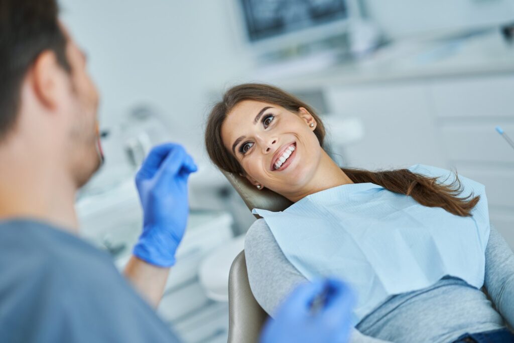 Dentist showing a patient a dental crown during a checkup
