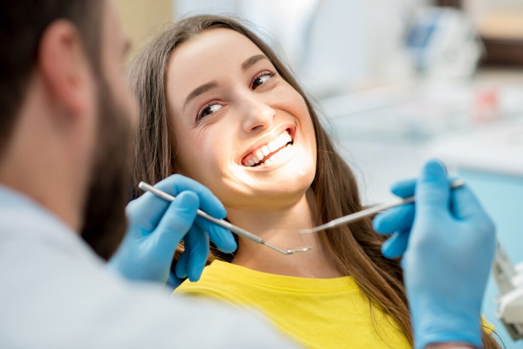 Dentist consulting with a smiling patient at a locally owned dental practice